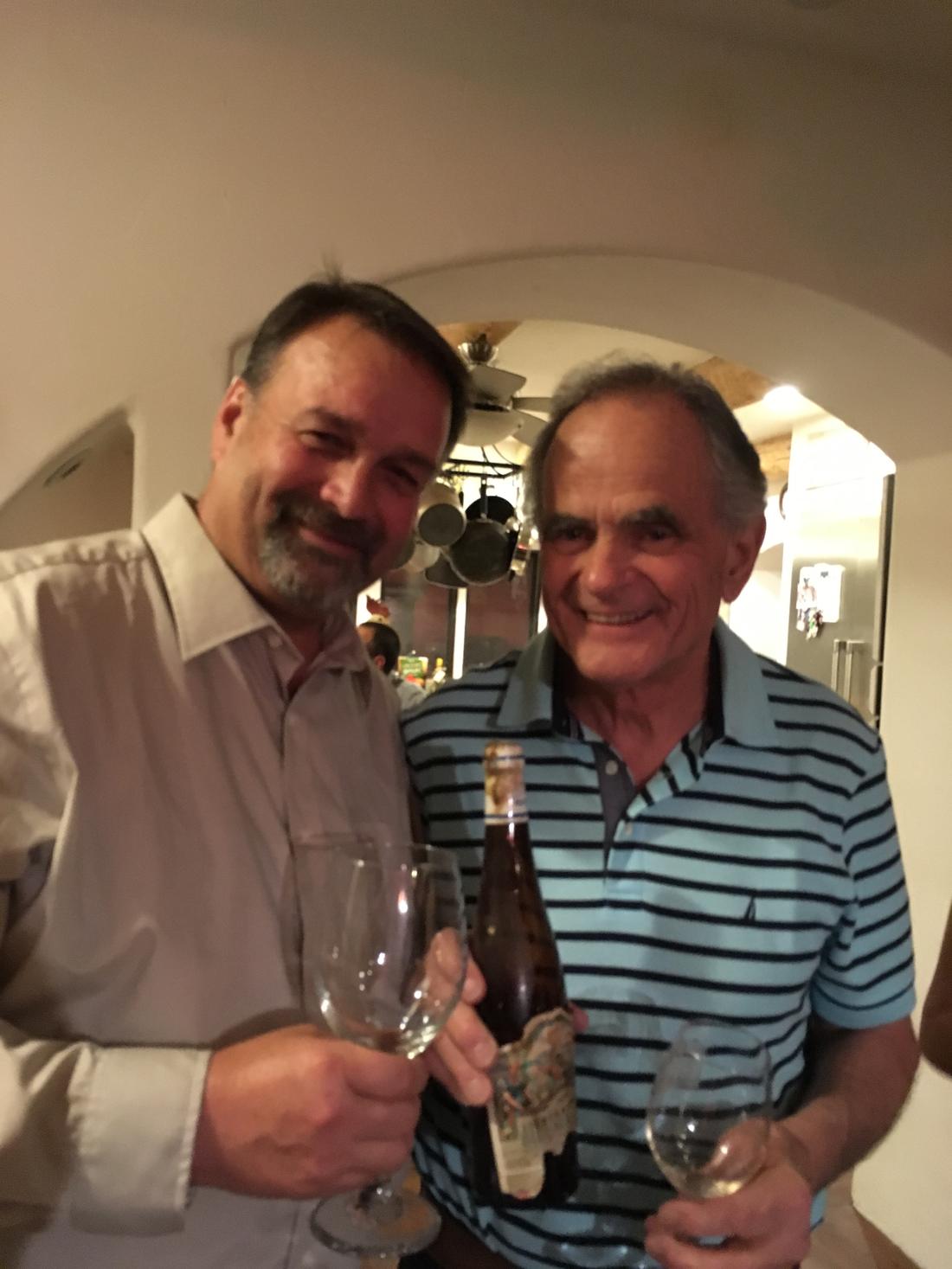 Two members raising glasses in the cellar doorway