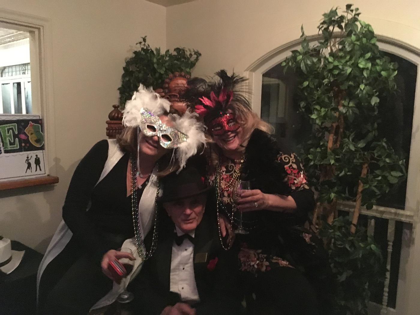 Members in masquerade masks at the mansion