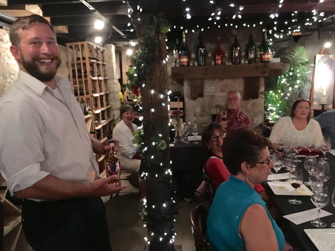 A member raising a glass by the cellar fireplace
