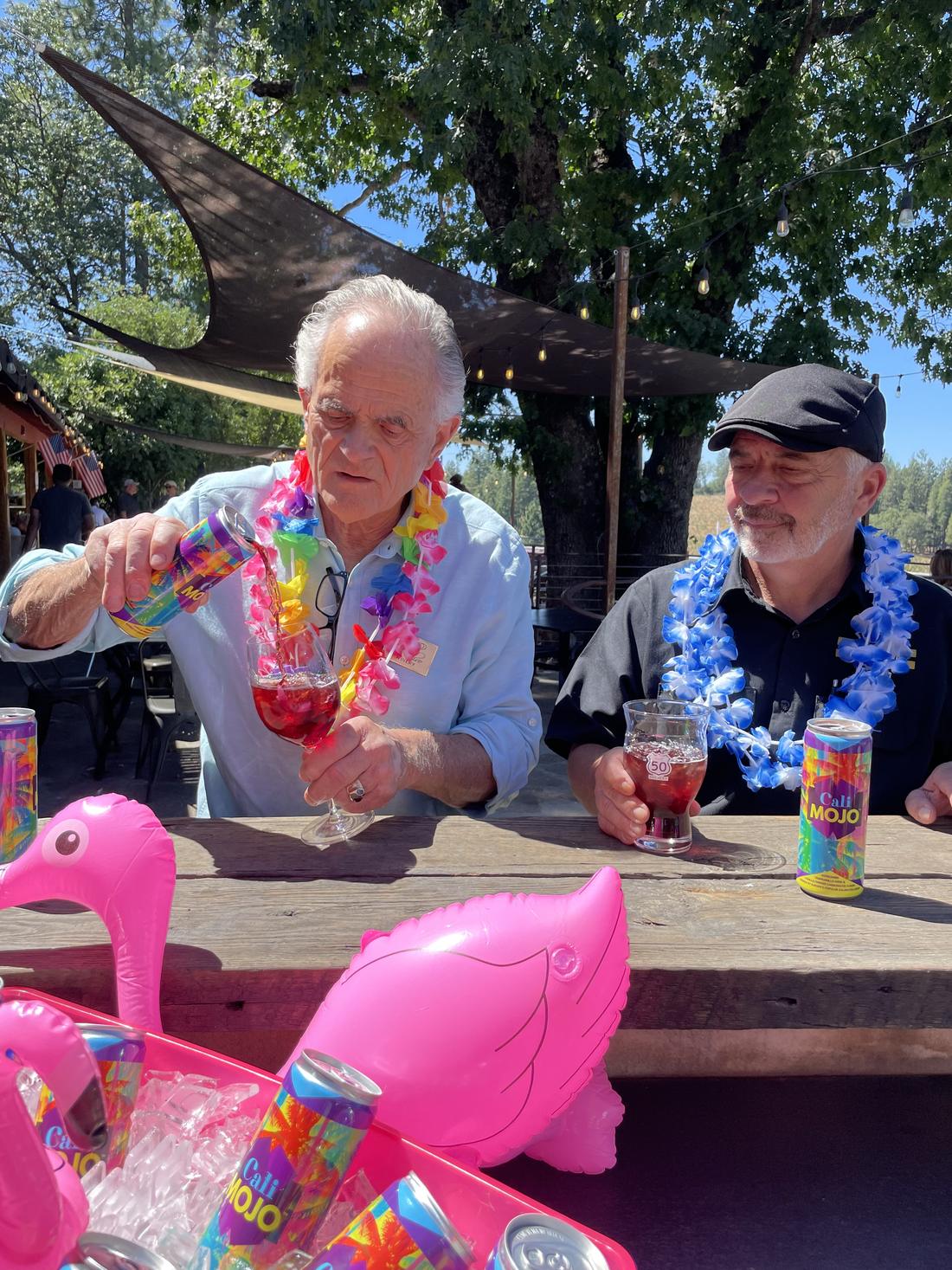 Two members in leis with the flamingo floatie