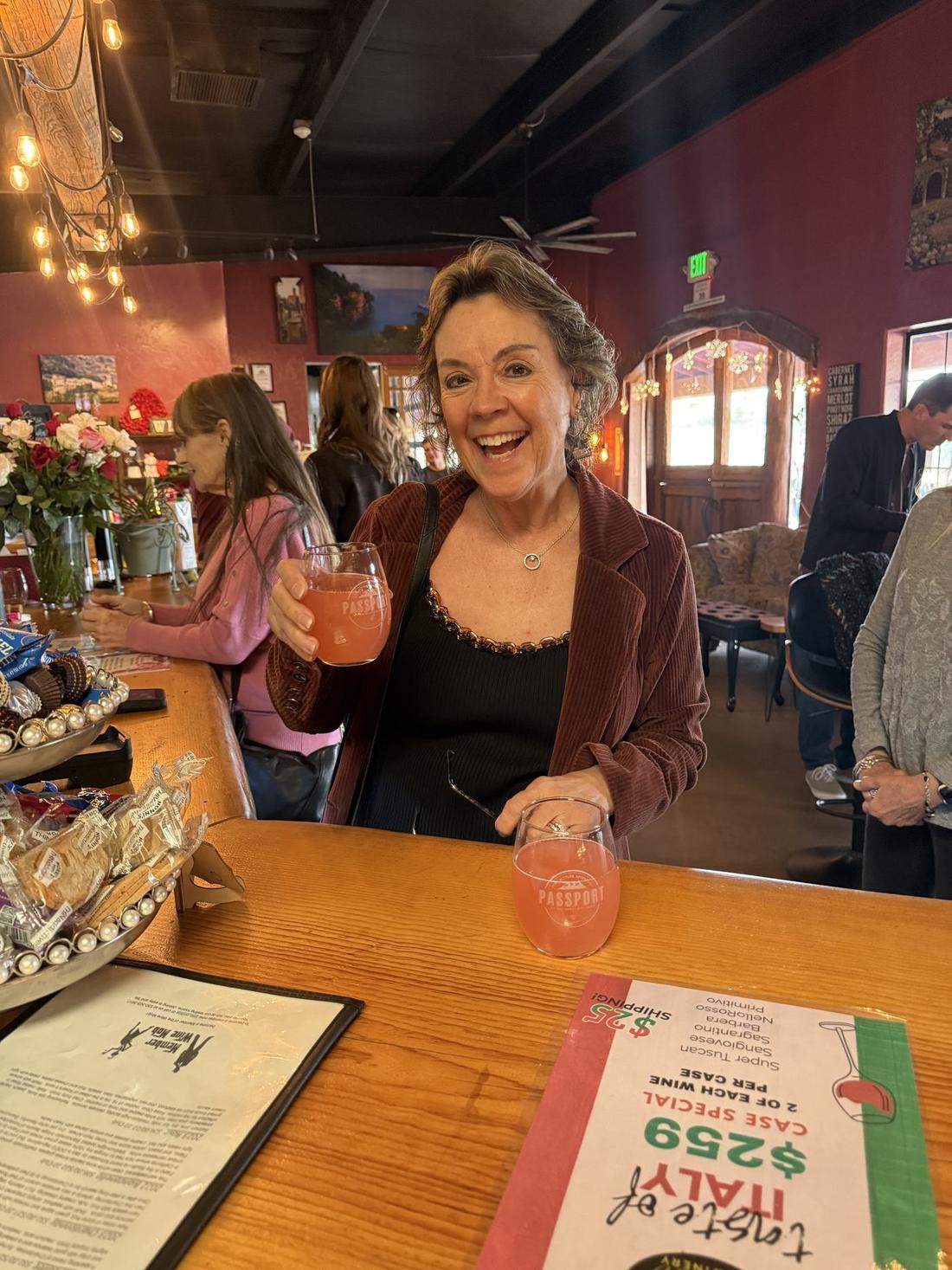 A member toasting with her Passport glass at the Camino bar