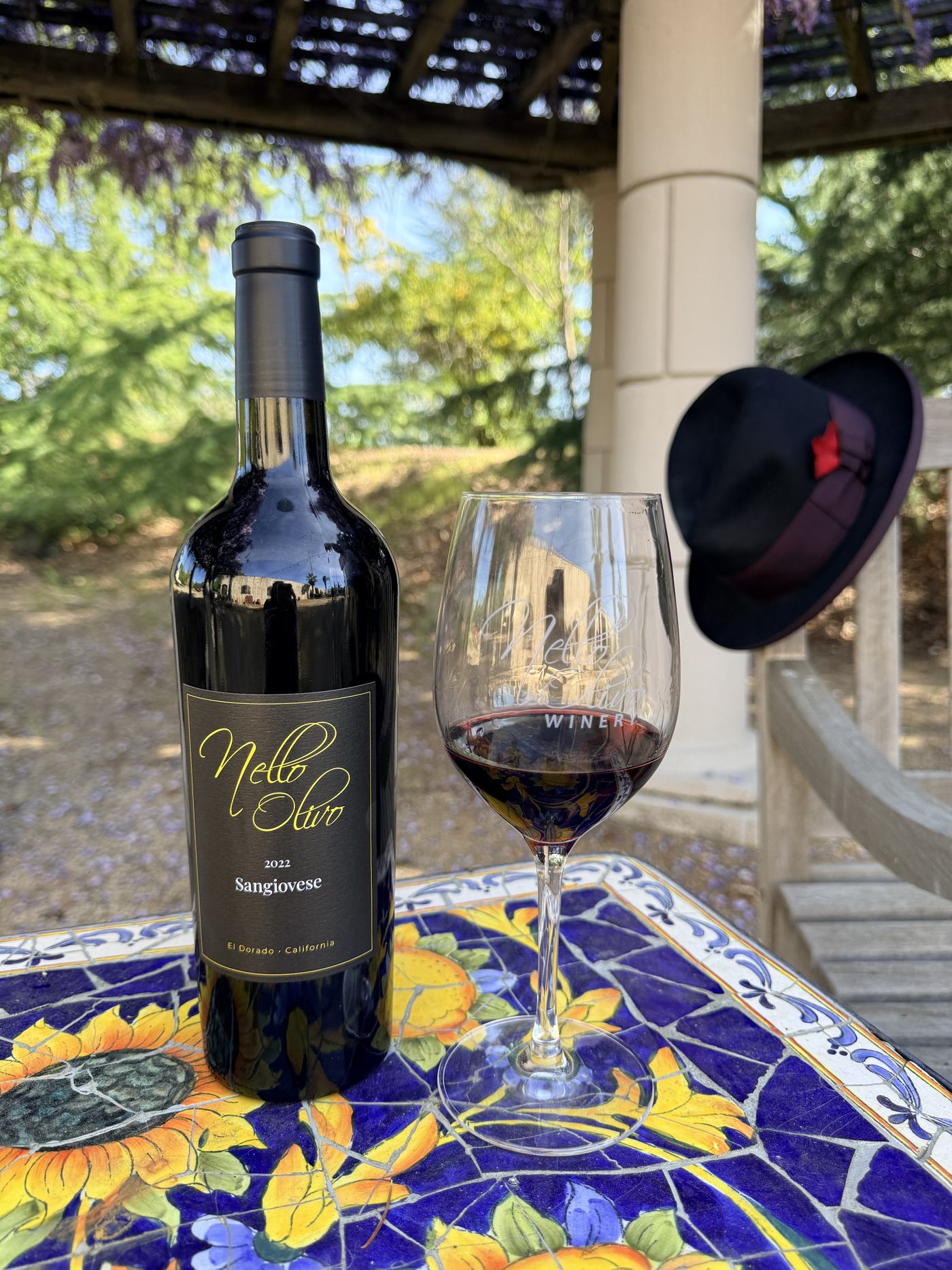 The 2022 Sangiovese on the tiled patio table under the wisteria