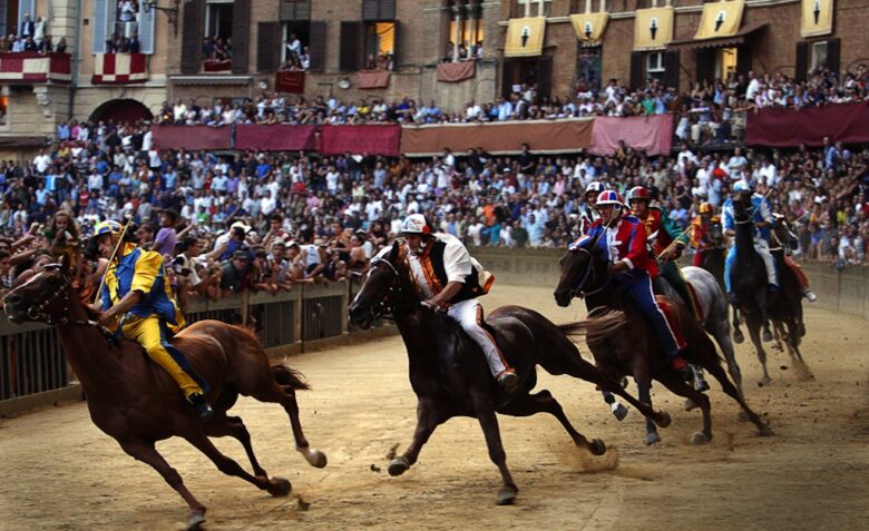 Horses and riders racing the Palio race in Siena Italy