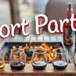 Port Party, 5 small glasses of port style dessert wines near a cozy patio firepit.