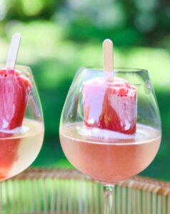 Bubbly wine and popsicle together in wine glass.