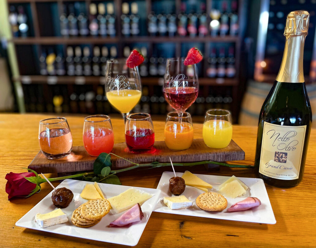 Flight of juices, bottle of bubbly, plates with small bites.